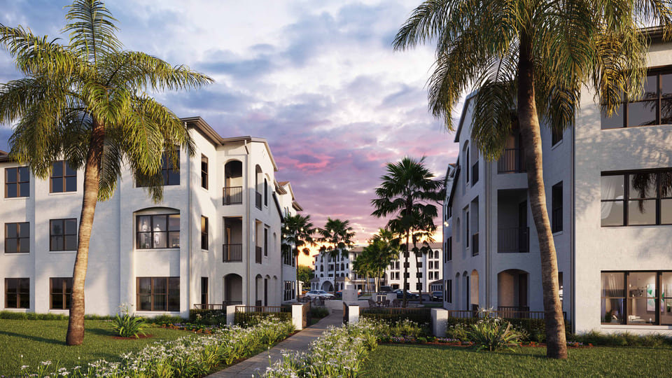 Multifamily courtyard with landscaped seating, palm trees, and pergola gathering areas.